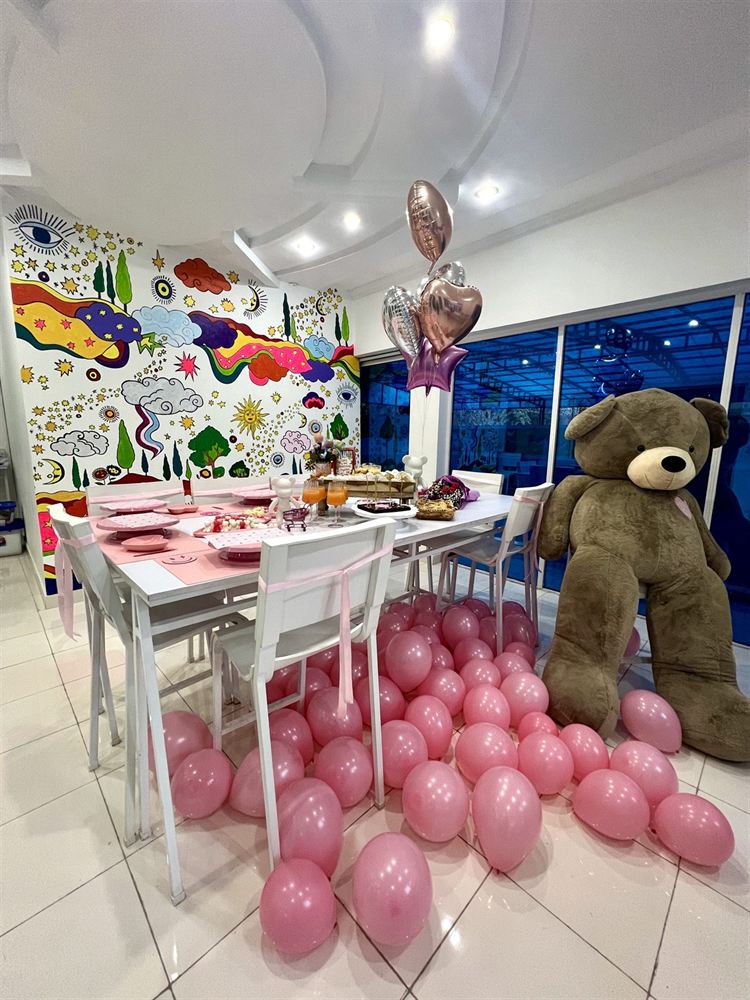 The studio set up for a private party, with pink balloons and a giant teddy